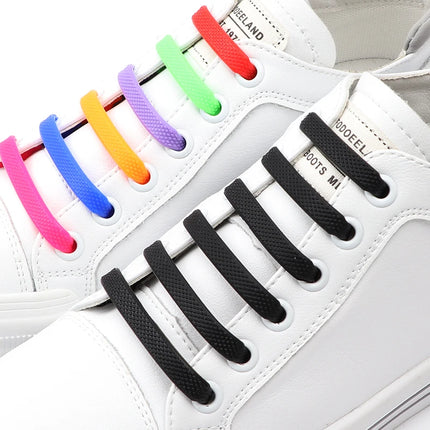 White sneakers with colorful shoelaces and black shoelaces on a white background

