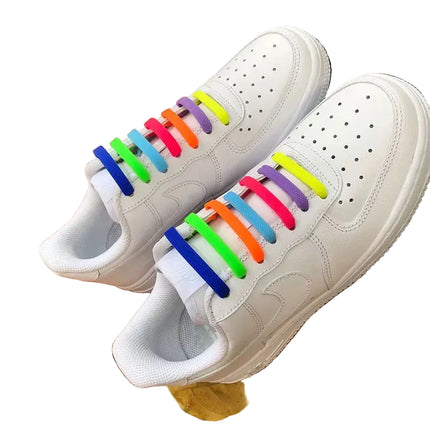 White sneakers with colorful shoelaces on a wooden surface

